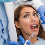 Angstpatientin mit besorgtem Blick beim Zahnarzt