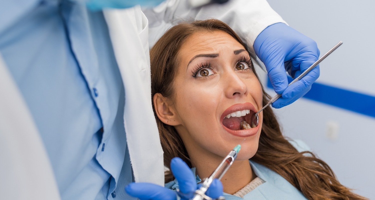 Angstpatientin mit besorgtem Blick beim Zahnarzt