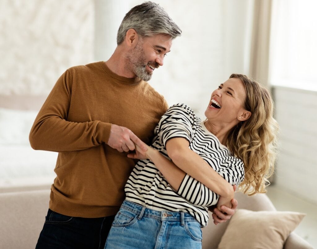 Glückliches Paar tanzt im Wohnzimmer