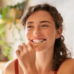 Frau putzt Zähne mit Bleching Zahncreme