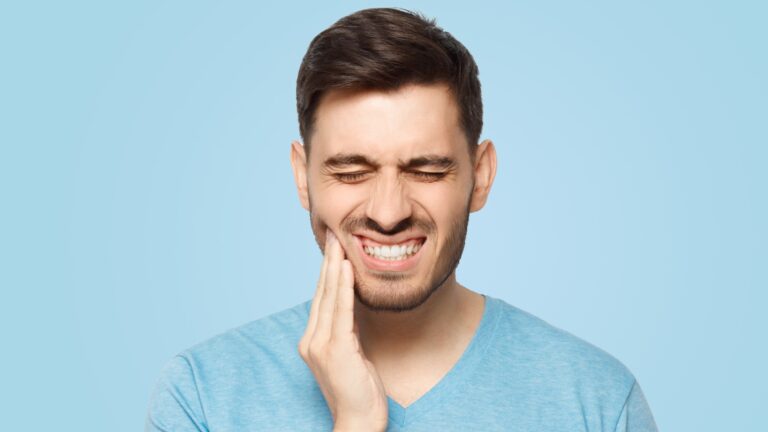 Man touching his face and closing eyes with expression of horrible suffer from aching tooth