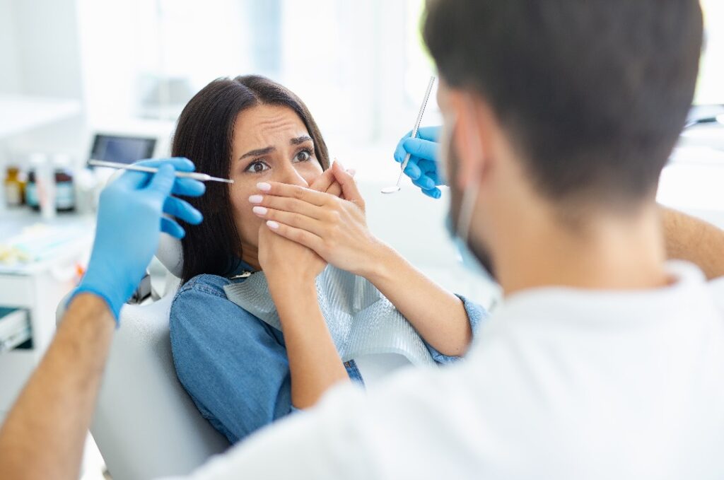 Eine Patientin hat Angst vor dem Zahnarzt in einer modernen Zahnklinik